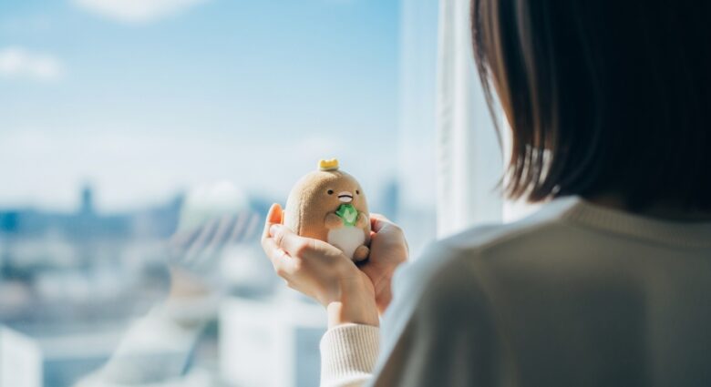 ぬいぐるみを優しく持つ女性の手